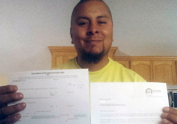 Marco Rodriguez receives his voter registration card from Covered California.