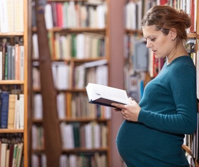 Pregnant woman reads in a library