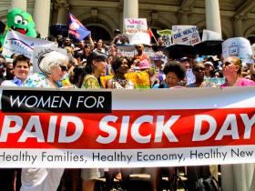 people protesting with a banner calling for paid sick days
