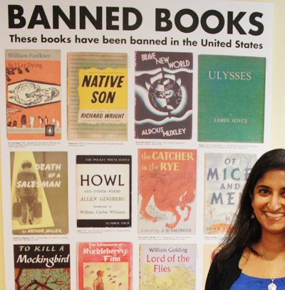 Laila Fahimuddin stands in front of an ACLU poster featuring banned books such as Howl and Native Son