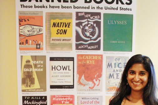 Laila Fahimuddin stands in front of an ACLU poster featuring banned books such as Howl and Native Son