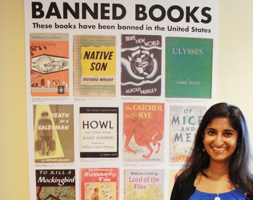 Laila Fahimuddin stands in front of an ACLU poster featuring banned books such as Howl and Native Son