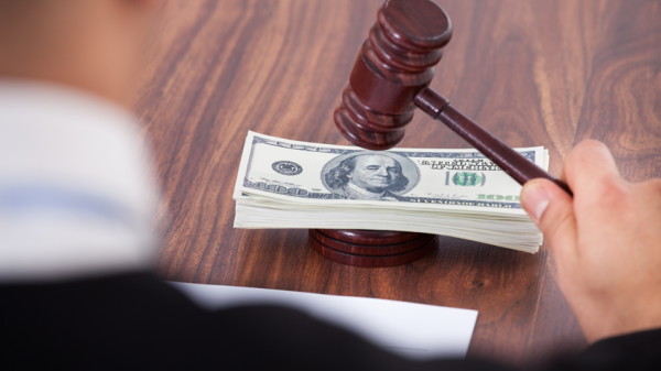 judge with gavel and stack of paper money on desk