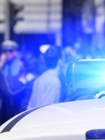 Police vehicle with a crowd in the background