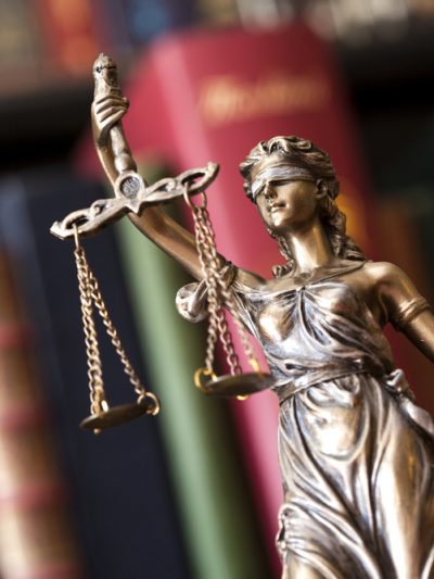 Justice statue in front of law books.