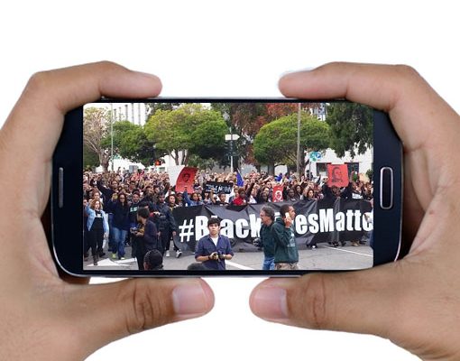 Cell phone in hands with Black Lives Matter protest on screen.