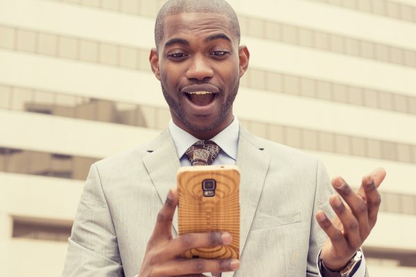 man looking into his smart phone - shutterstock