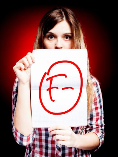 young person holding a graded paper with an 'F'