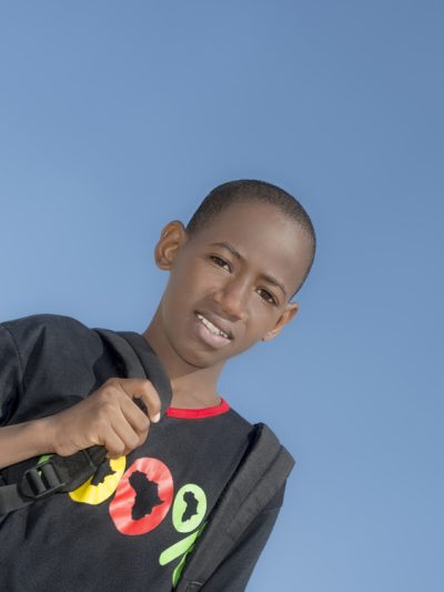 stock photo of a school aged youth of color wearing a backpack