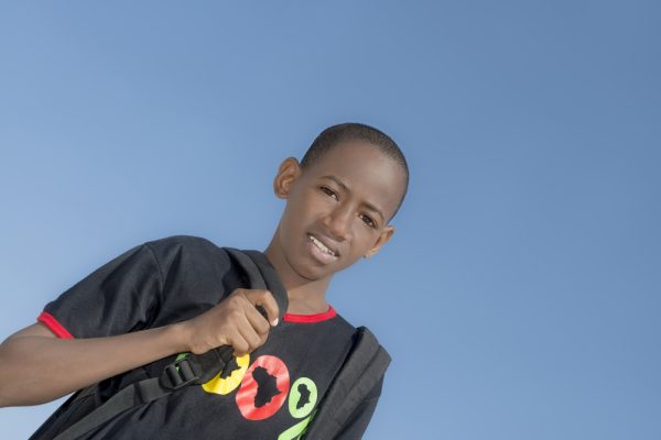 stock photo of a school aged youth of color wearing a backpack