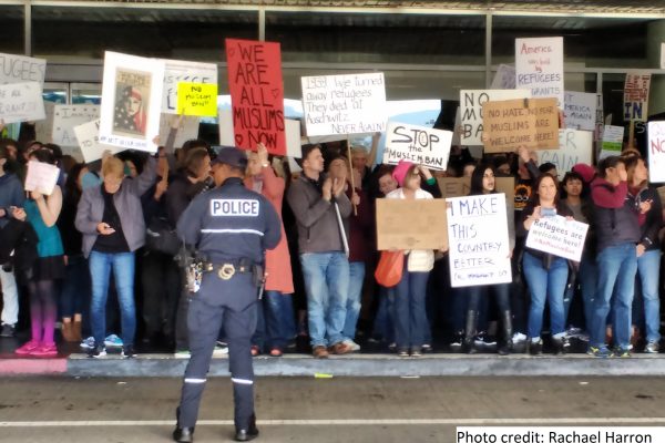 Protesters at SFO hold signs speaking out against the Muslim ban