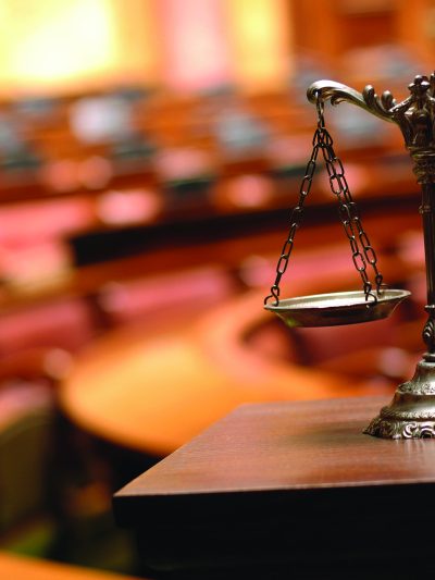 scales of justice in front of a court room