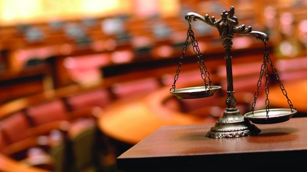 scales of justice in front of a court room