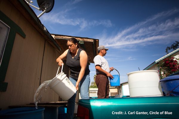 person dumping bucket of water