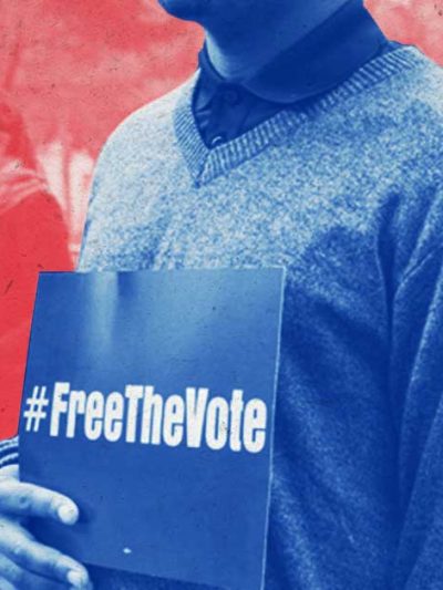 person holding a #freethevote sign in front of a crowd of people