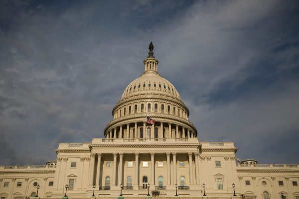 A photograph of the U.S. Capitol with stormy clouds in the background