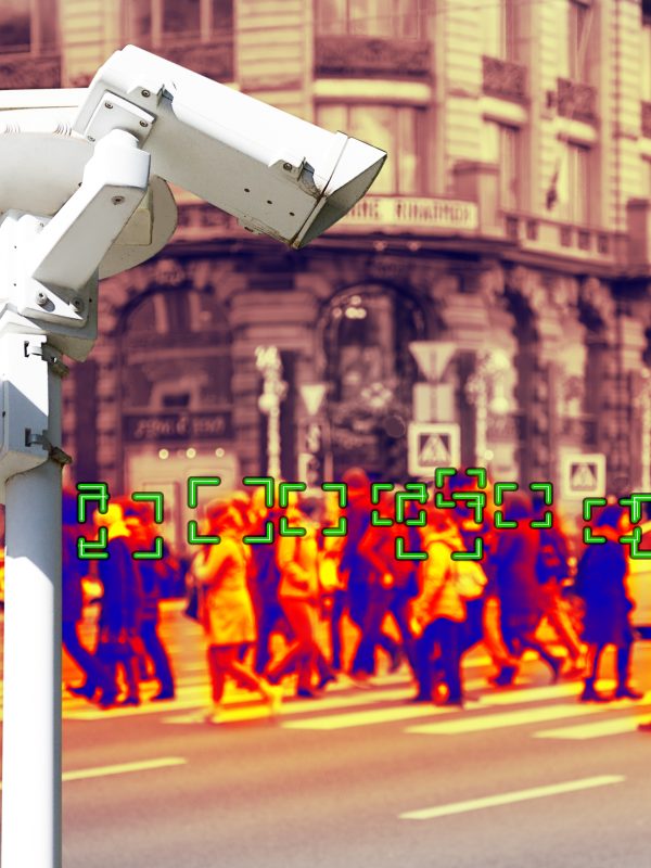 A photograph of surveillance camera in the foreground with a heat map of a gathered crowd in the background.