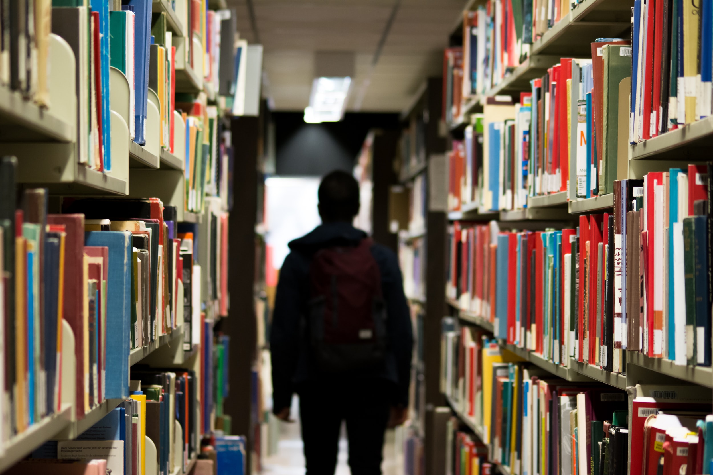student walking down an aisle in the library