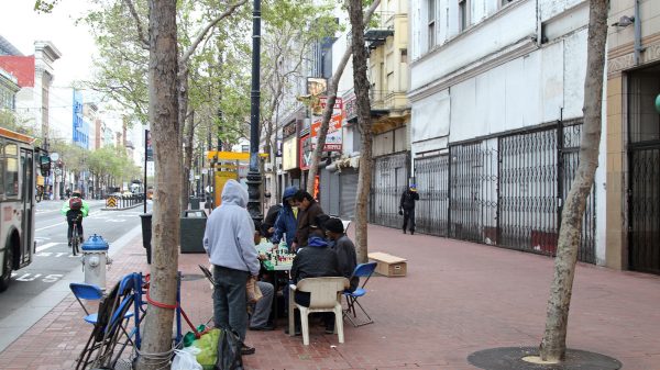 People play chess in the early evening along Market St in the Tenderloin neighbourhood, near the intersection with Turk and Mason Streets. San Francisco, California, USA.