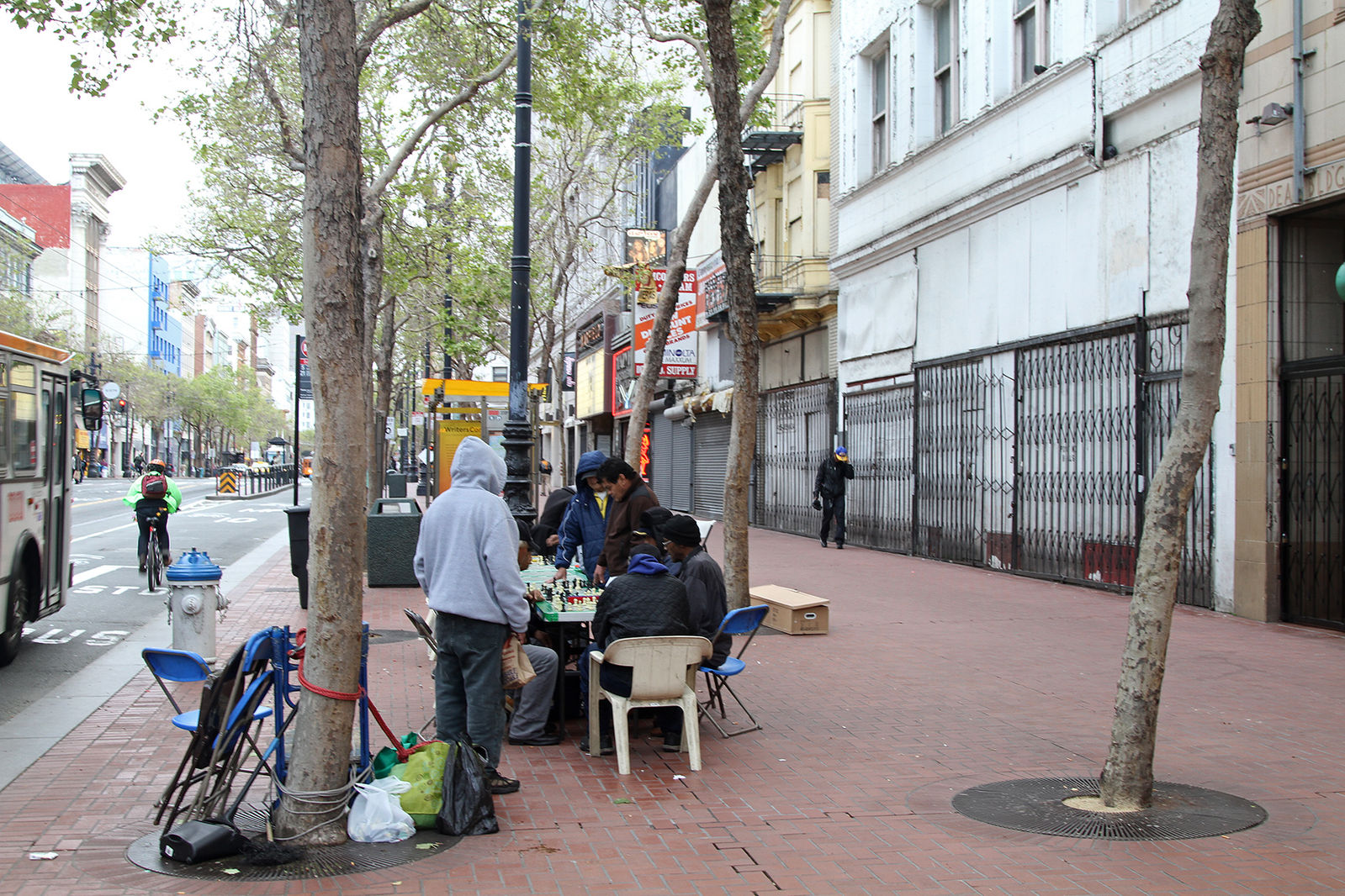People play chess in the early evening along Market St in the Tenderloin neighbourhood, near the intersection with Turk and Mason Streets. San Francisco, California, USA.