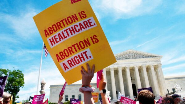 Poster being held up that reads Abortion is healthcare, Abortion is a right