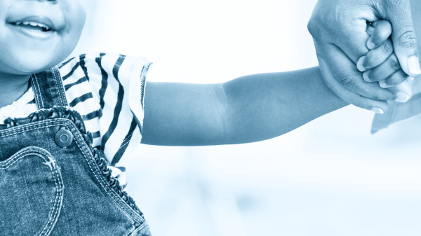 A photo of a young child holding her mother's hand.