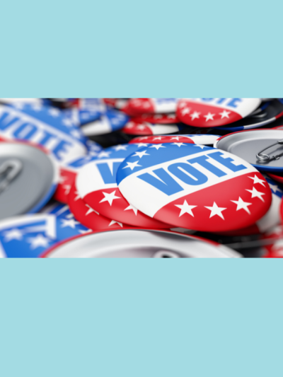 A photo of red, white, and blue buttons that say vote.
