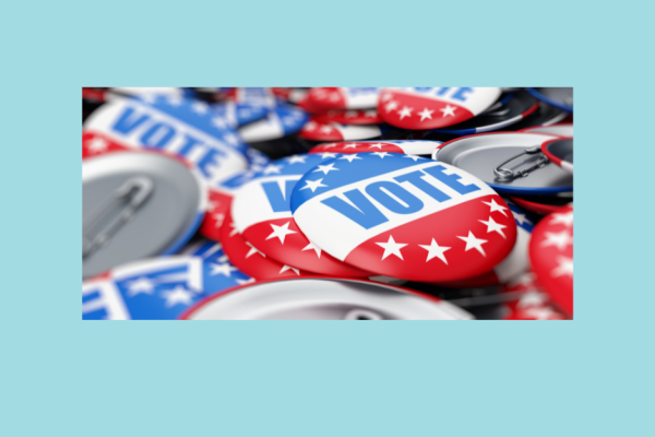 A photo of red, white, and blue buttons that say vote.