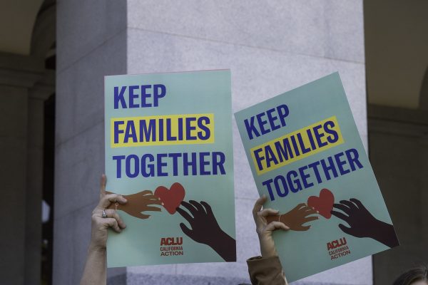Two hands holding aloft signs that say Keep Families Together