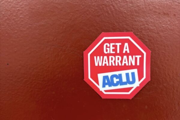 ACLU "get a warrant" sticker on a red background