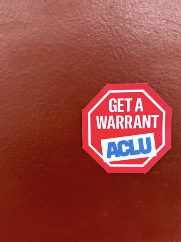 ACLU "get a warrant" sticker on a red background