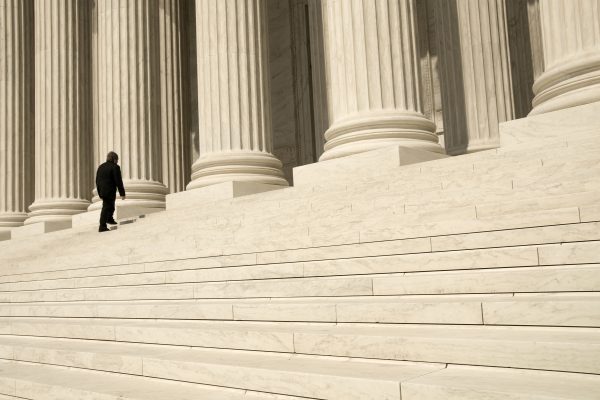 A man ascending the steps at the entrance to the US Supreme Court in Washington, DC.