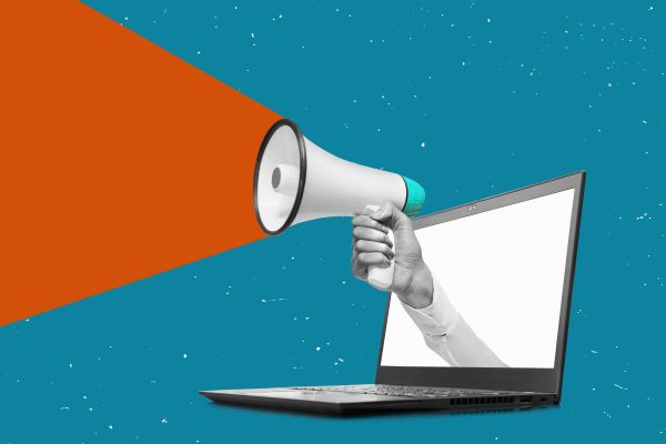 Hand holding a megaphone from laptop monitor