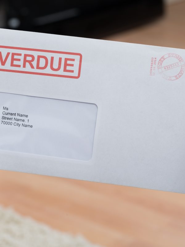 Close-up Of Person's Hand Holding Overdue Notice