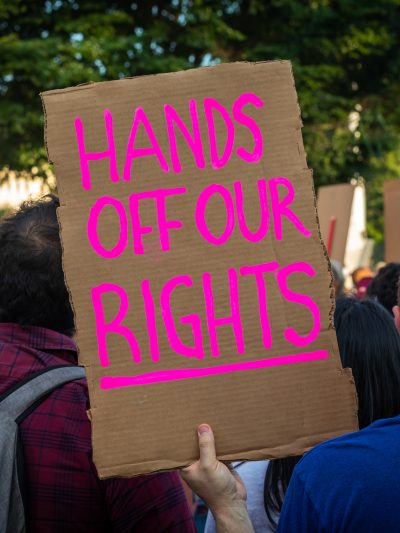 Protestor holds sign reading "Hands off our Rights"