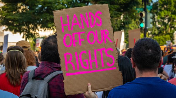 Protestor holds sign reading "Hands off our Rights"