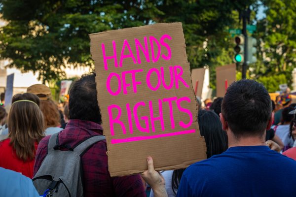 Protestor holds sign reading "Hands off our Rights"