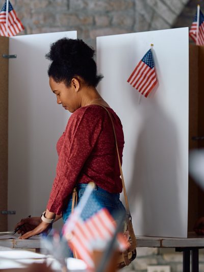 African American woman at voting booth during US elections