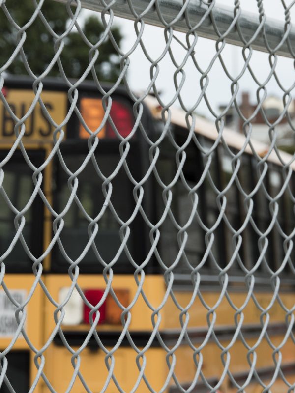 School Bus Parked Behind Chain Link Fence