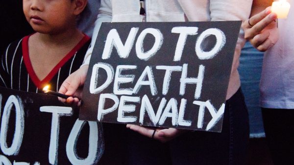 Black sign with white writing reading "No To Death Penalty."