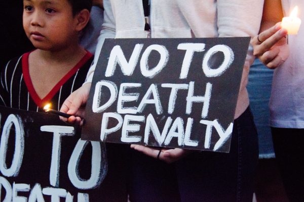 Black sign with white writing reading "No To Death Penalty."