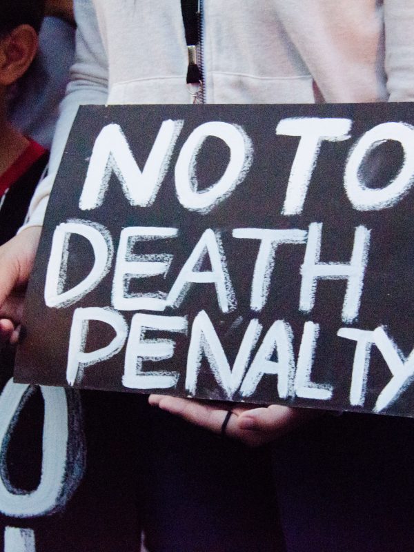 Black sign with white writing reading "No To Death Penalty."