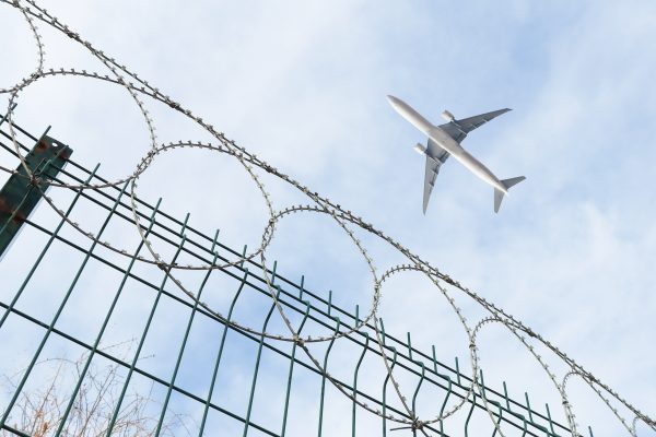 airplane flying over barbed wire