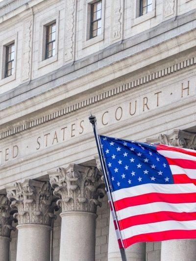 U.S. flag waving in the wind in front of United States Court House