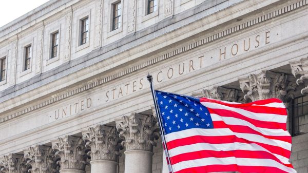 U.S. flag waving in the wind in front of United States Court House