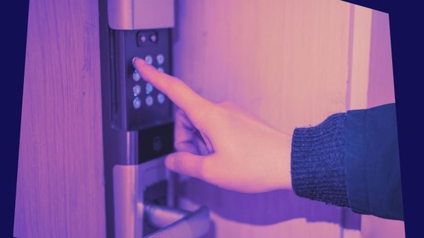 A hand pressing button on a digital door lock