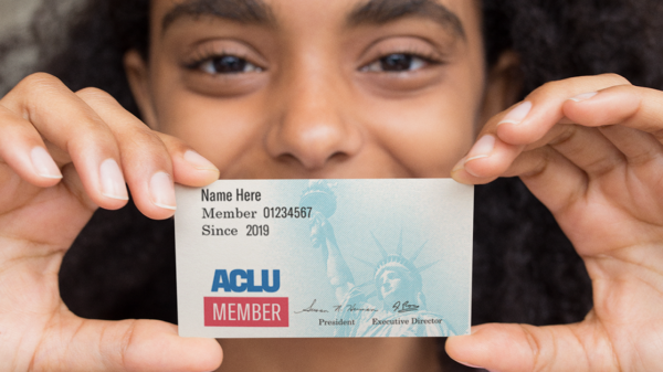 person holding up an aclu membership card over their face