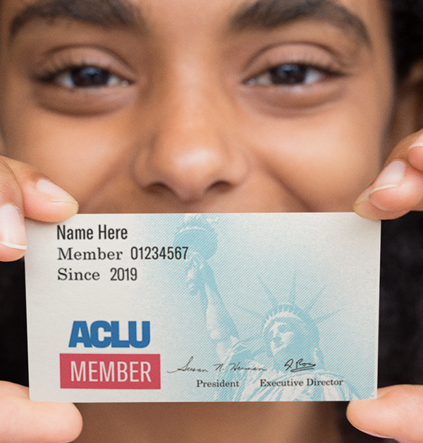 person holding up an aclu membership card over their face