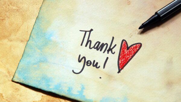 A note card with the words "Thank you!" in black ink with a red heart