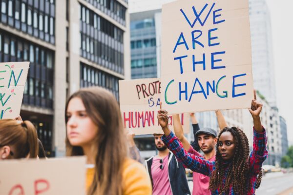Amid a protest, one person carries a sign that read "We are the change"
